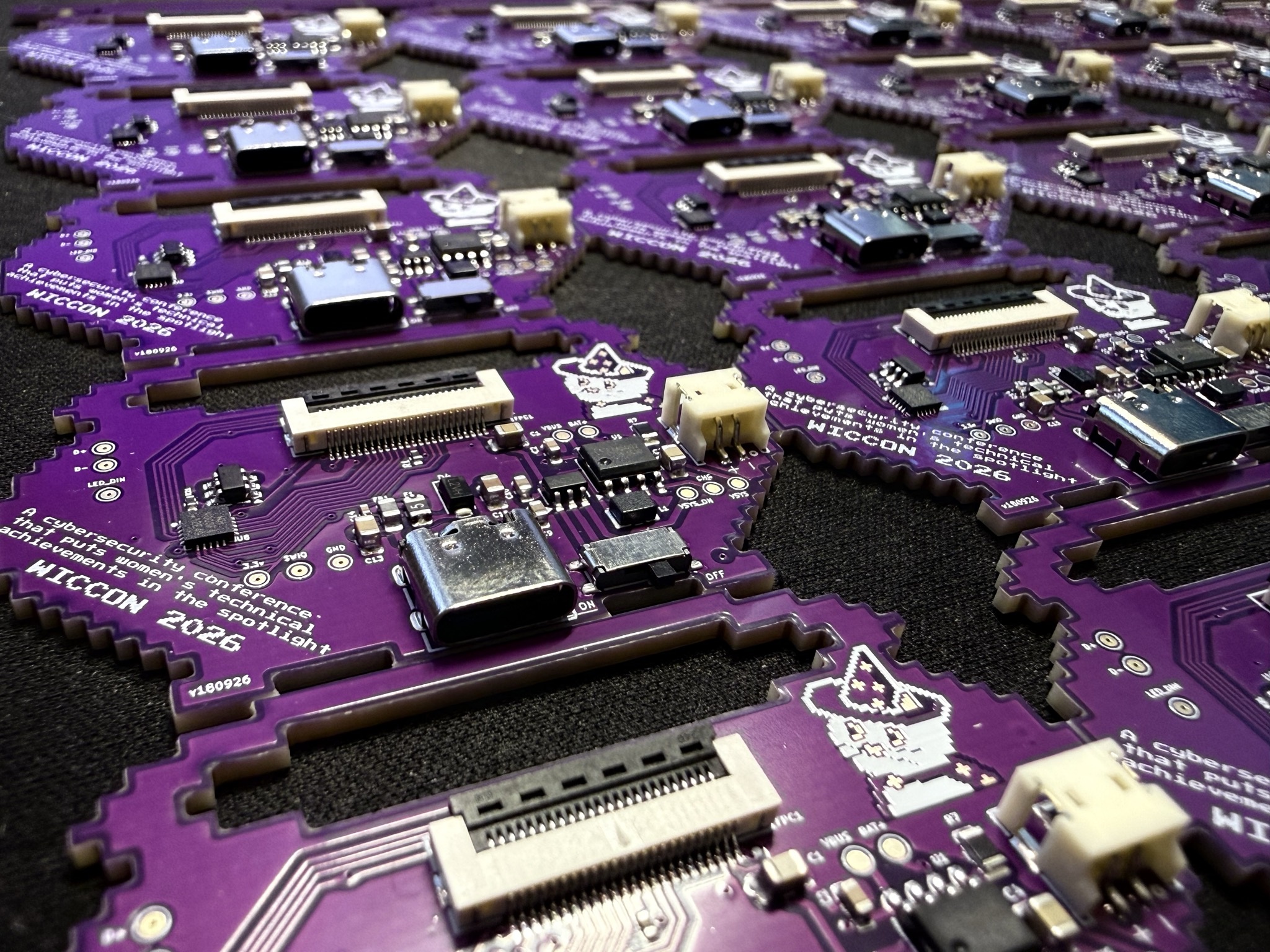 Array of purple WICCON 2026 badges fresh off the production line